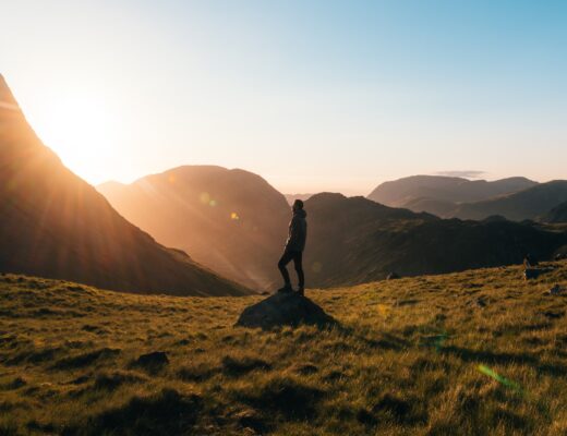 /silhouette-photography-of-person-standing-on-green-grass